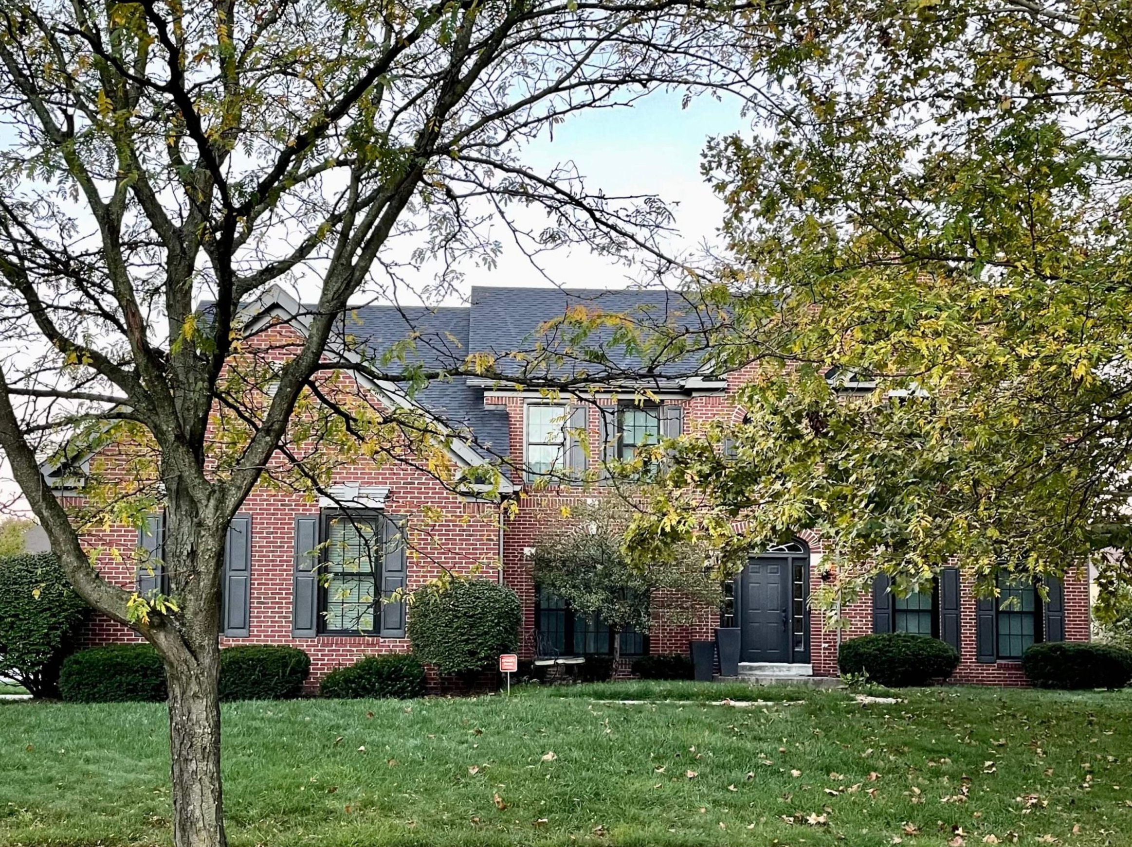 Red Brick Exterior with Timeless Navy Shutters